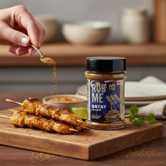 Hartekiste Angus & Oink peanut-free Satay spice rub being sprinkled over grilled chicken skewers on a wooden board
